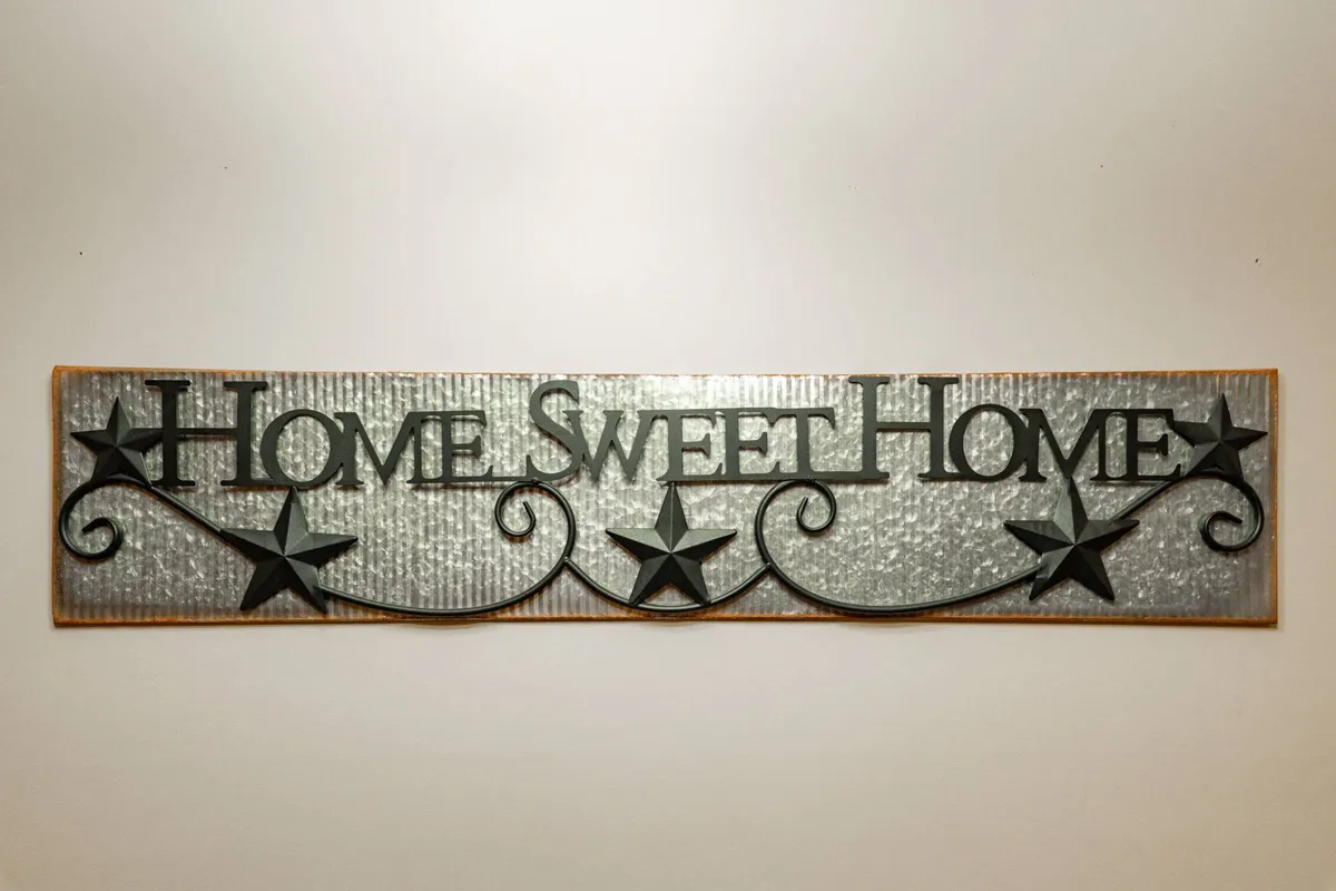 A close-up of a 'Home Sweet Home' sign welcoming guests, with a softly lit, inviting background that sets the tone for comfort and hospitality.