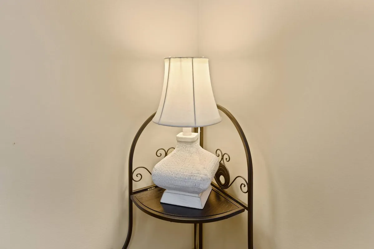 A warmly-lit table and lamp create an inviting corner perfect for reading, relaxing, or enjoying a quiet cup of tea. The setup conveys comfort and provides an intimate view of the home's relaxing environment, ideal for winding down after busy family outings.